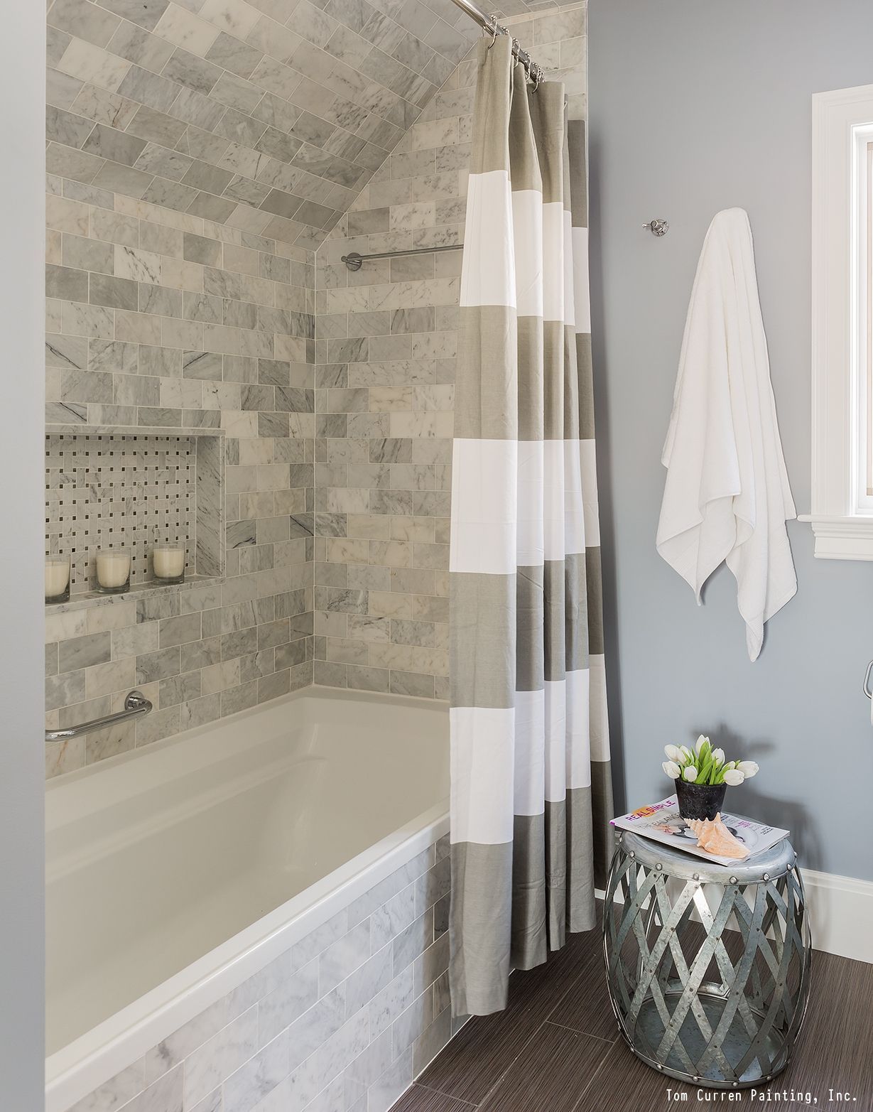 A gorgeous bathroom remodel with a tile shower, white trim and a fresh coat of blu