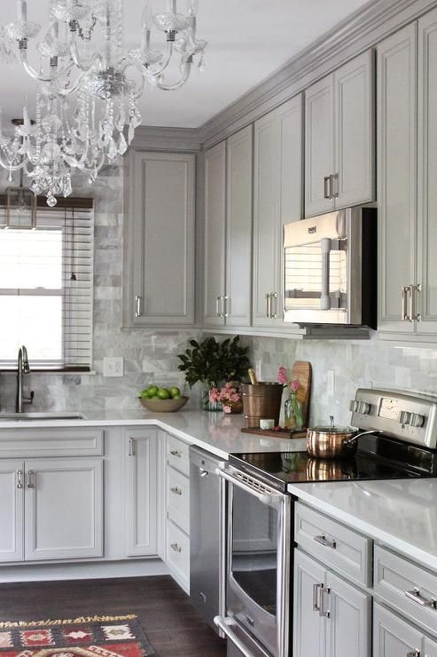 Gray kitchen features gray raised panel cabinets paired with Viatera Snow Storm…