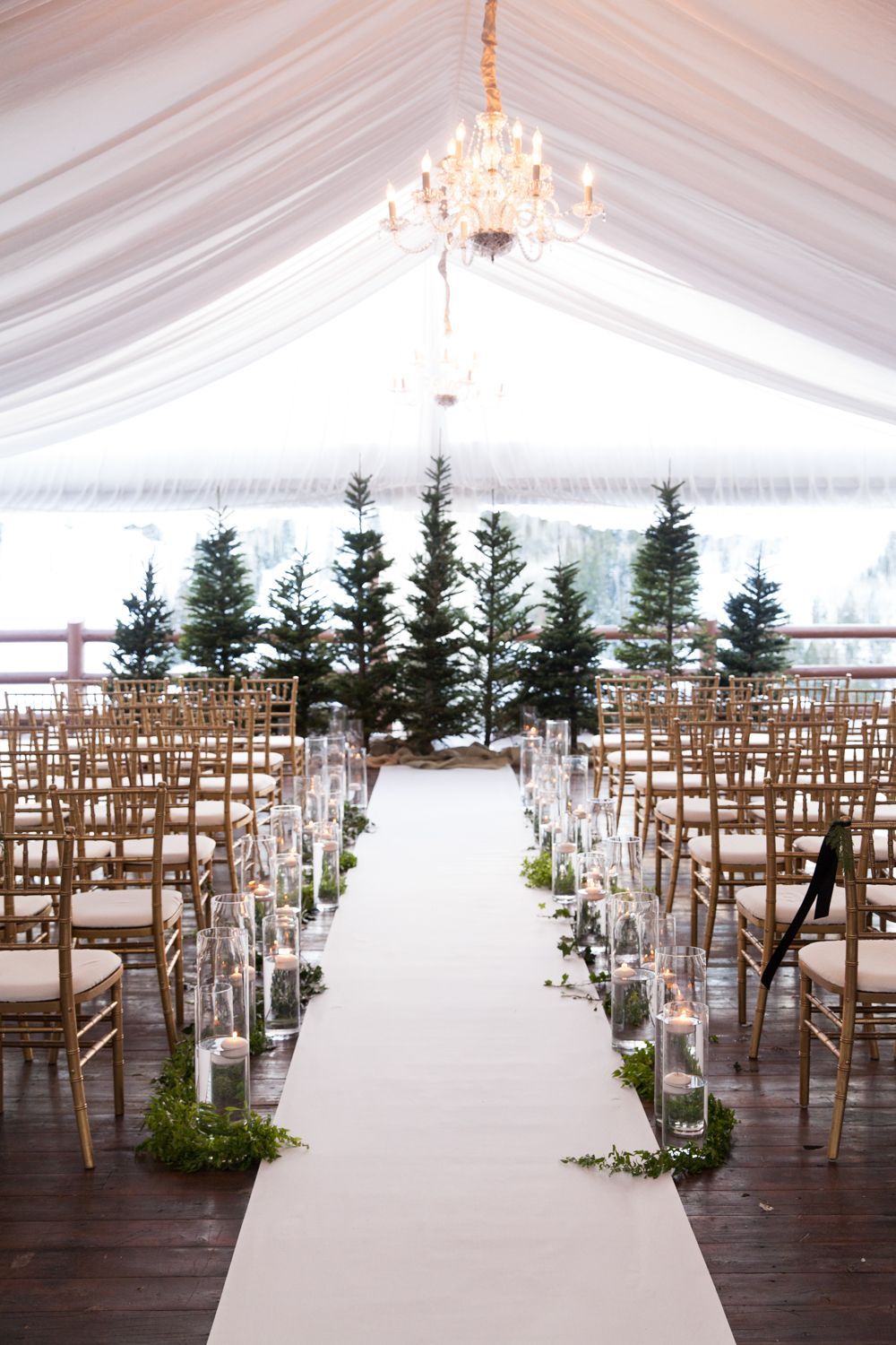 Tented wedding ceremony with evergreen trees and candles | Winter wedding at Stein