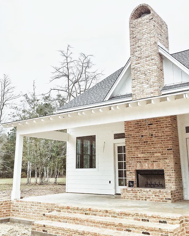 Outdoor fireplace – white farmhouse – black windows – exposed rafters on porch (not sure what its called)