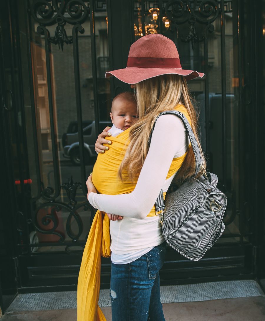 fall floppy hat & yellow baby wrap are cute accessories on this mama