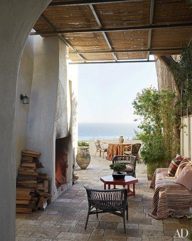 The stone terrace of designer and antiques dealer Richard Shapiro’s Malibu beach house is furnished with rattan and wicker
