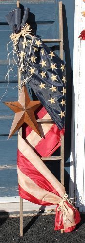Adorned with a tea-stained Americana flag** and accented with a rusty star and raffia bow, this ladder will be a great addition to