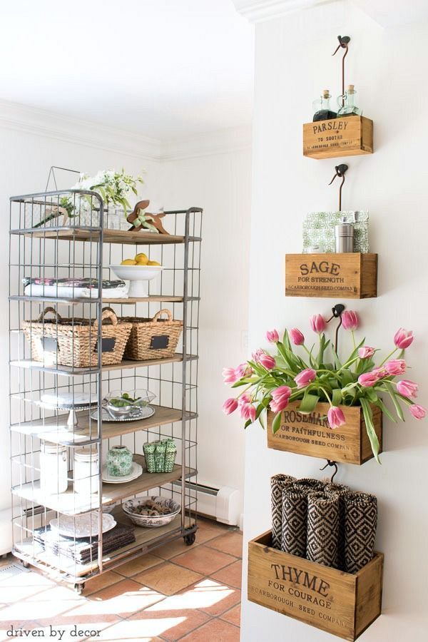 Kitchen with farmhouse style – wall-mounted nesting herb crates filled with tabletop necessities and farmhouse bakers rack