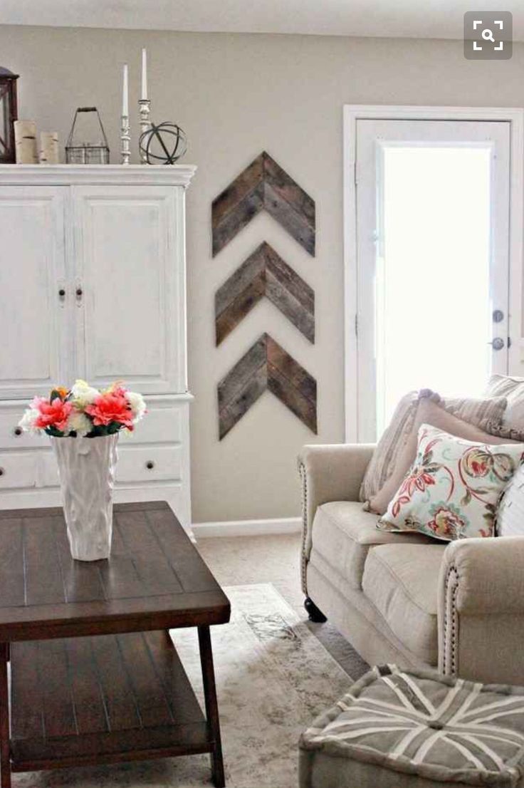 Living Room decor – rustic farmhouse style. Rustic reclaimed wood arrows, painted white armoire, neutral color palette.