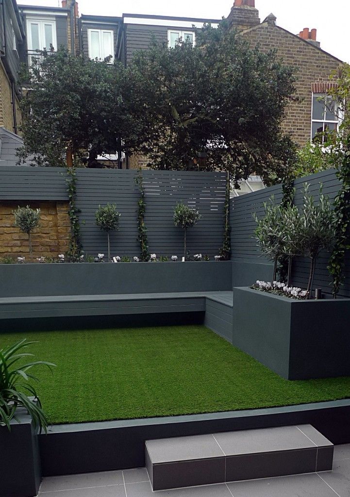 Raised beds grey colour scheme agapanthus olives artificial grass porcelain grey tiles yellow stock brick walls grey Floating