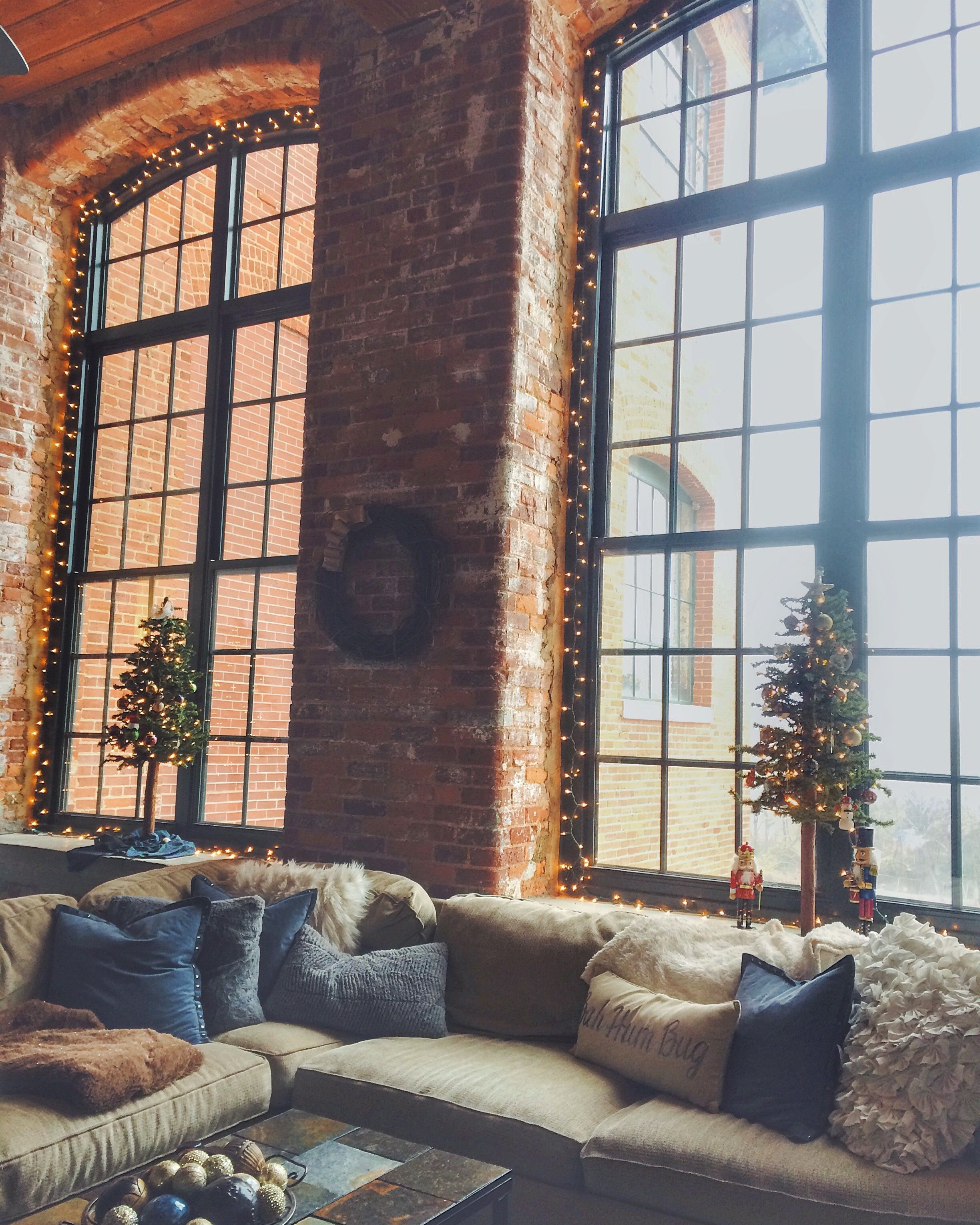 Cozy loft style apartment – christmas decor. Exposed brick wall with tall ceilings and stained concrete floors. Old cotton mill.