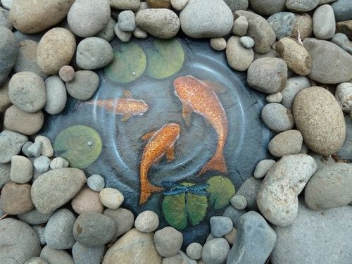 Fish painted on a slate rock…surrounded by river rock…cute for a small  garden