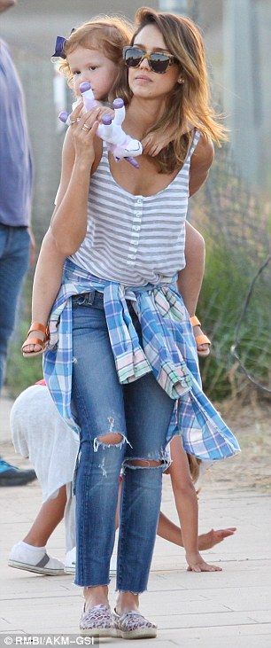 Muscle mum: Jessica was seen carrying her daughter in her arms, as well as on her back…