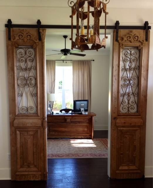 Our Antique French iron doors hung barn door style.  Also, dont miss the custom desk designed from French antique doors!