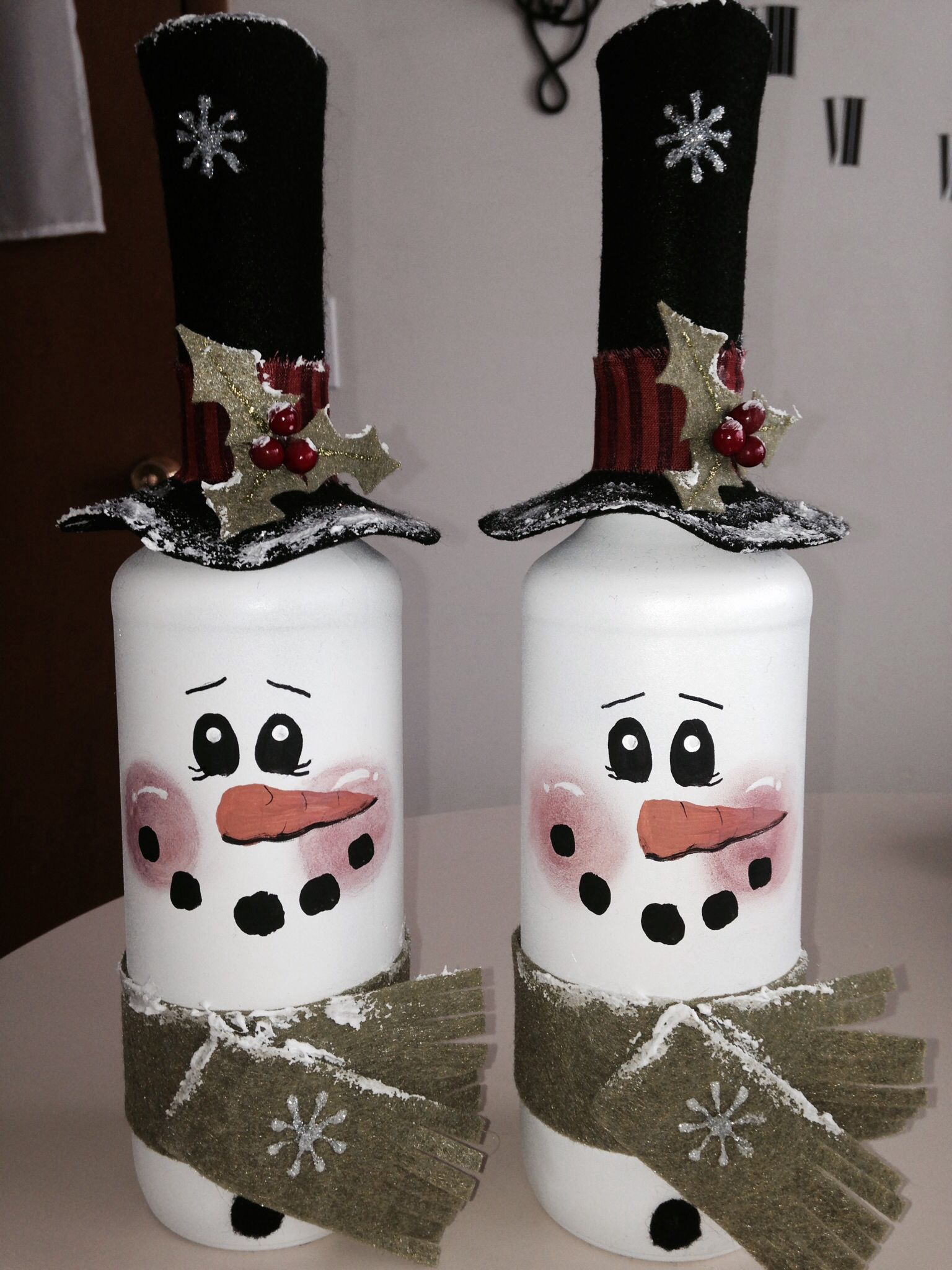 Spray painted wine bottles with painted faces and felt accessories! (Hat comes off to add lights inside bottle)
