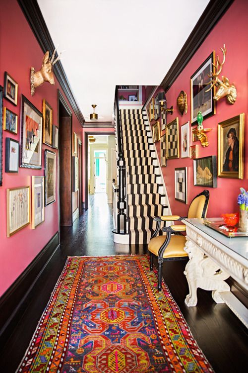 coral colored walls mixed with dark oak flooring + a white ceiling, finished with a cache of vintage art + eclectic accessories