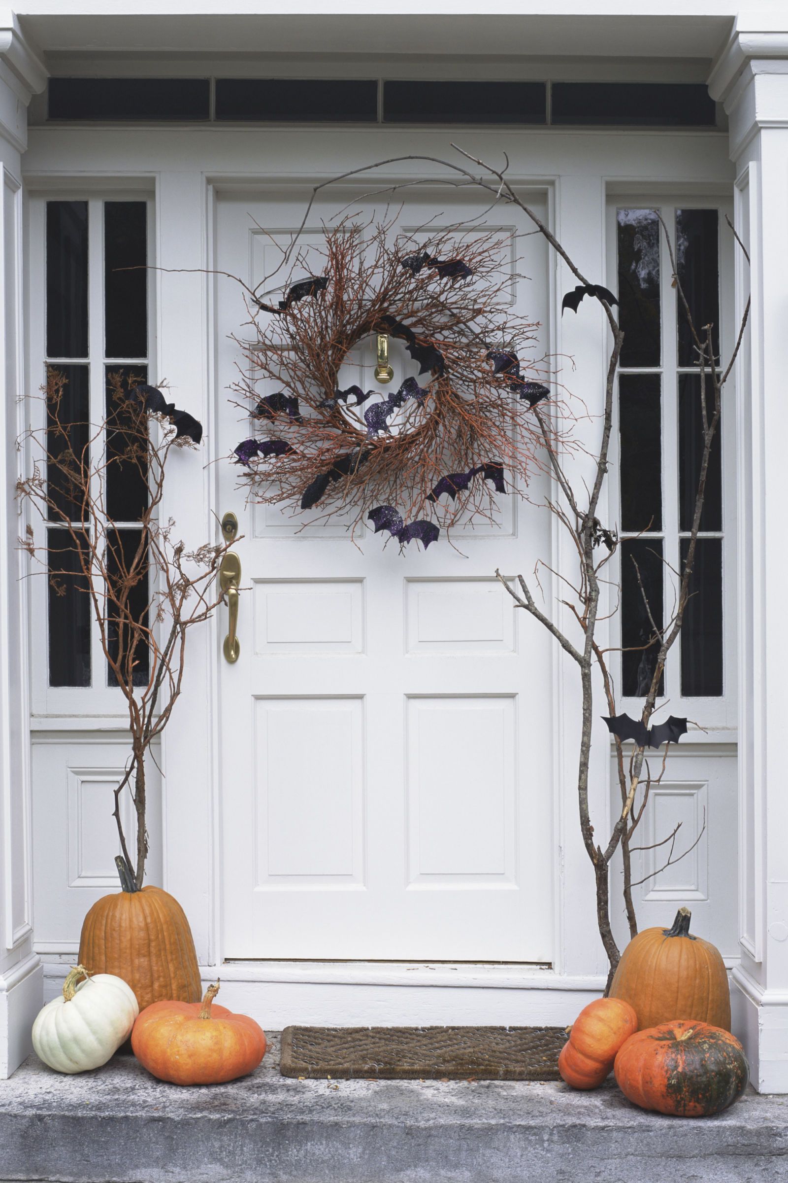 Hang a rustic spooky wreath from your door. Use vines and chic black bats. As simple as that.