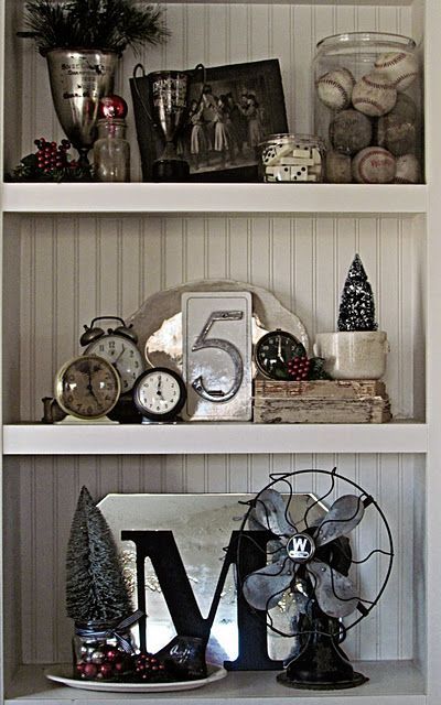 I love the vintage masculine feel to this vignette…vintage fan, collection of dominoes, baseballs, and clocks