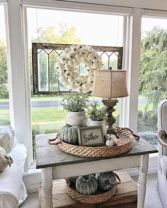 A textured wicker tray looks beautiful with greenery and a rustic lamp as the focus