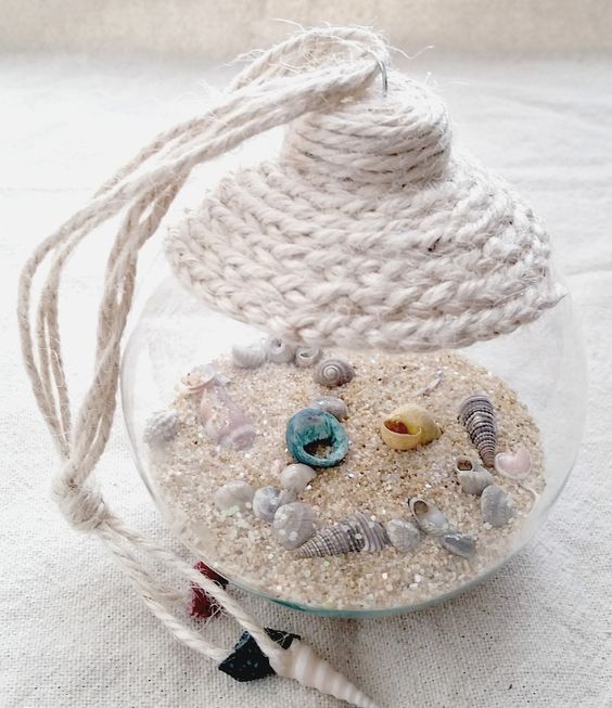 An easy craft tutorial on how to make a beach in a glass coastal ornament. A great way to show off shells collected during the