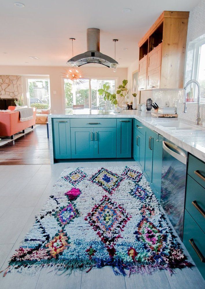 Love the color of the cabinets and the coral furnishings for this boho kitchen.