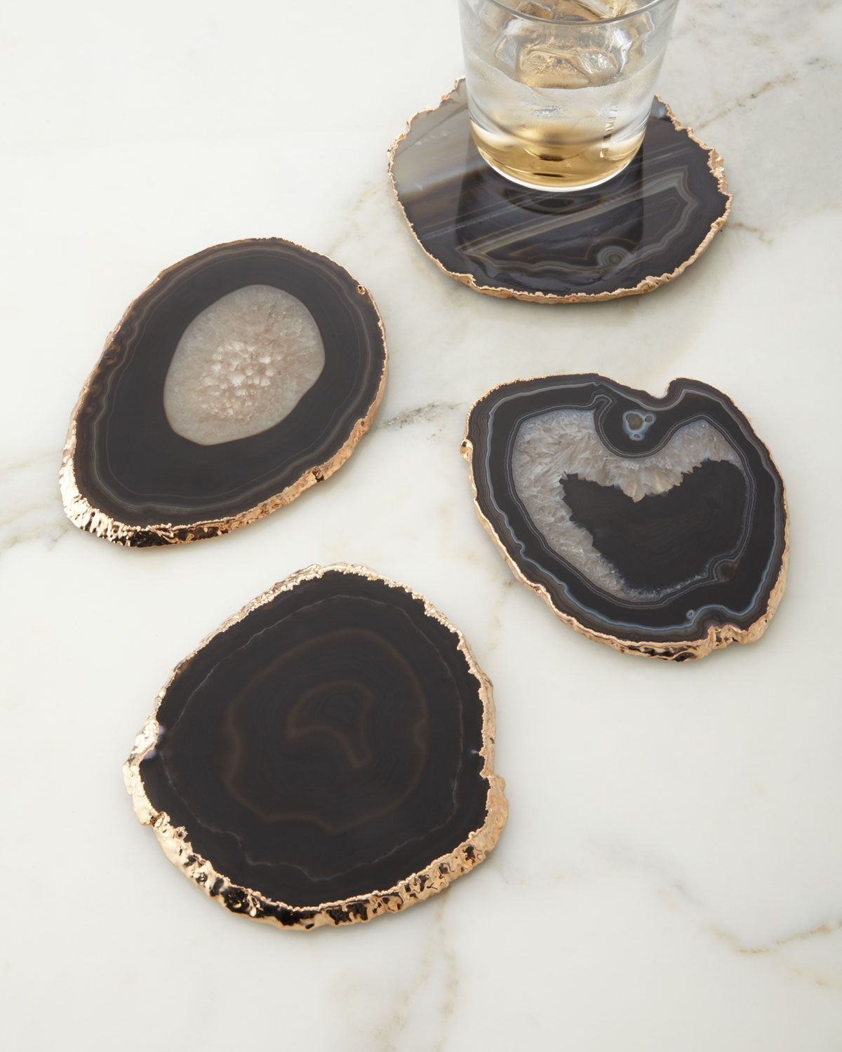 Handcrafted coasters. Natural agate edged with 18-kt. gold plating. Size, shape, and color of stone will vary. Set of four; each,