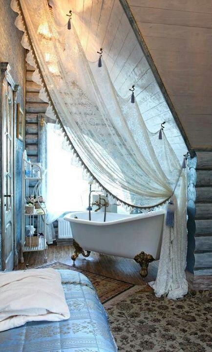 Rustic bedroom with bathtub in a private corner, facing a large window, with a lace curtain