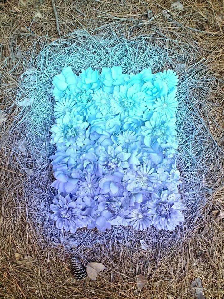 Get a canvas or cardboard and some fake flowers then glue the flowers on it and spray paint it with 2-3 colors to add some color