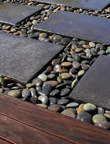 Modern backyard landscaping ideas with beach pebbles.