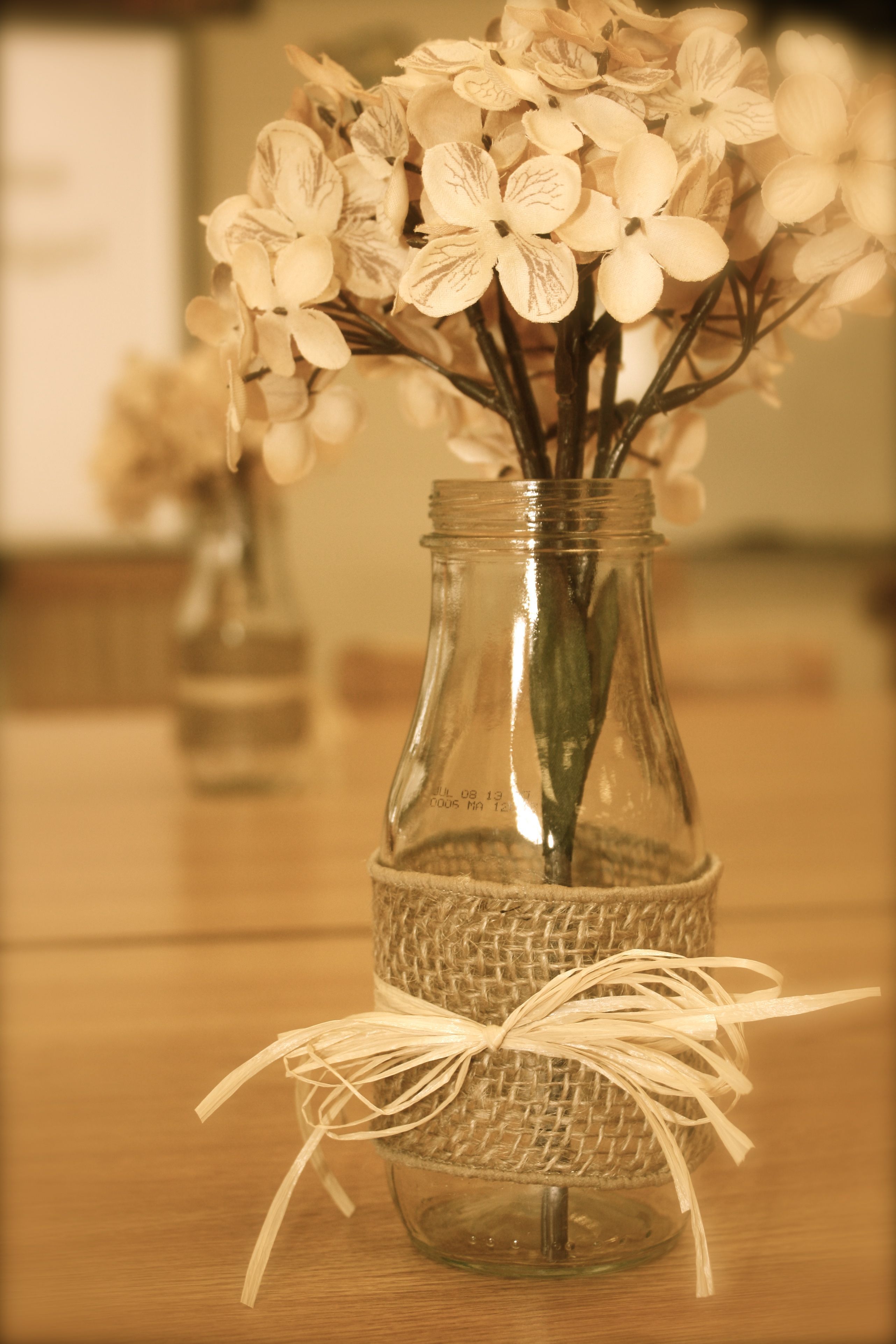 Table decorations made from Starbucks Frappucino bottles, burlap and raffia!