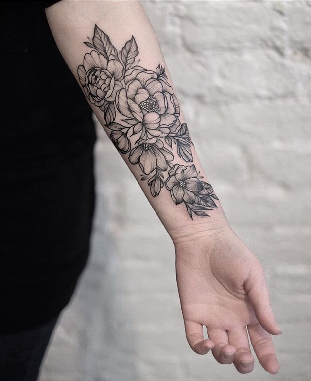 Trinity has a sleeve covering her right arm. The sleeve is a collection of realistic, black and white flowers. After having been