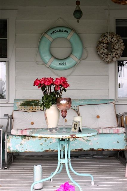 Diggin this beachy porch with distress blue glider and lifer-ring. I’d loose the shell wreath and just let it be
