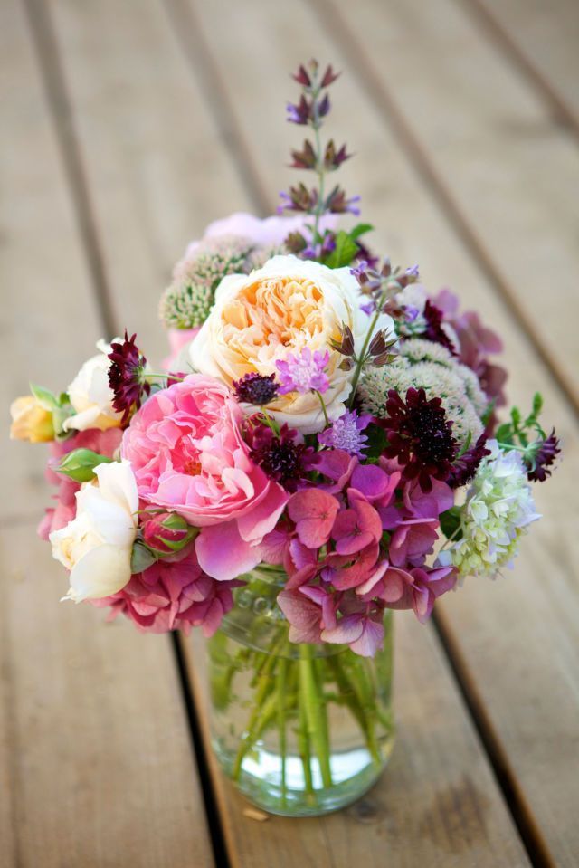 Switch off between placing bold peonies and smaller flower varieties in a clear vase for an arrangement that is loaded with