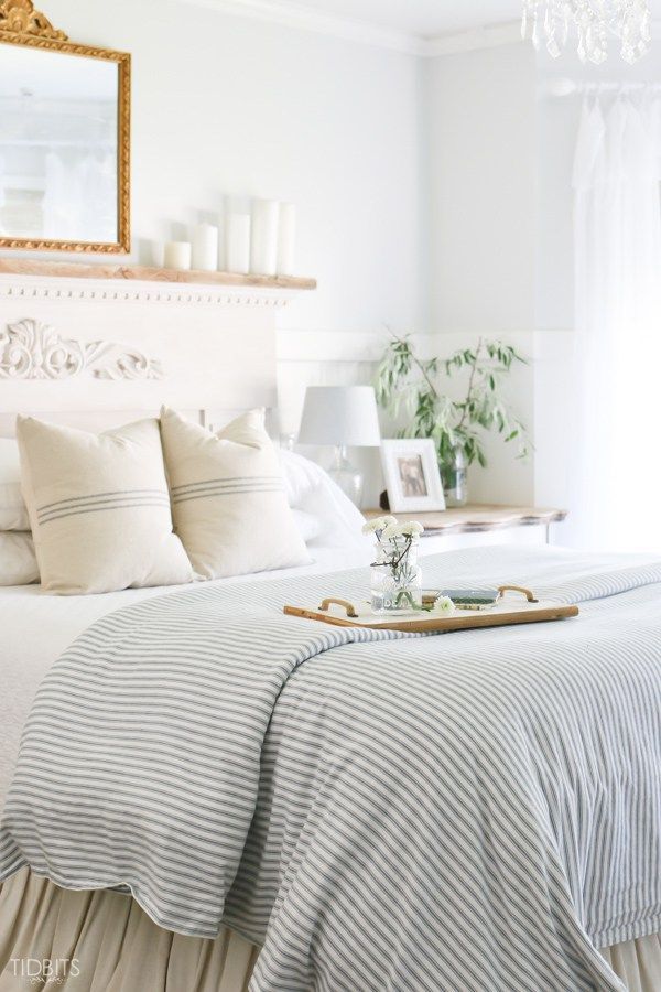 White cottage style bedroom accented with blue and white grain sack pillows and a blue and white seersucker comforter