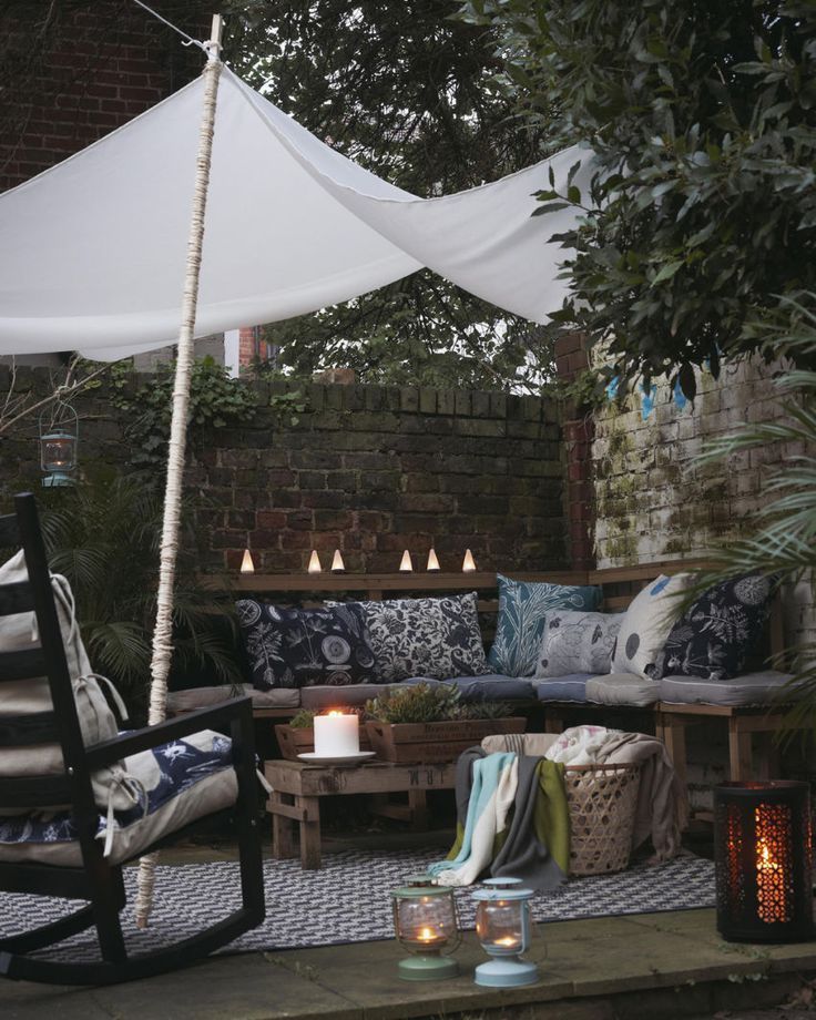 Create a cosy bench area with cushions, throws and lighting -   24 small courtyard garden
 ideas