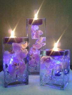 A set of three square vases with purple orchids floating in water perfect for unique wedding recepti -   7 wedding Centerpieces orchids ideas
